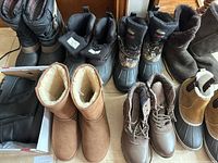 Overview photo showing eight pairs of women's boots including Eddie Bauer and other brands in various winter styles and colors. Condition ranges from like new to lightly used.