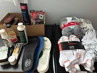 Multiple products including socks and shoe care items on table.