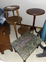 Photo showing four wooden plant stands, the wooden step stool and vintage floral sewing stool all grouped together in a corner on carpet.