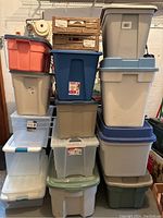 Full view of stacked plastic storage bins in various colors and two wooden crates