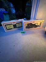 Two Model Power train items in original packaging: black Canadian National steam locomotive and Toronto Hamilton Buffalo boxcar.