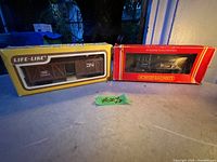 Both boxed model trains: a Life-Like HO scale stock car and a Hornby Railways 00 gauge diesel model in original boxes placed side by side.