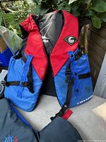 Two red and blue life jackets branded Connelly with front buckle closures, displayed hanging