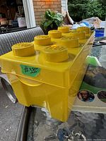 Yellow LEGO storage box shaped like a LEGO brick with 8 studs and seller's lot number #335.