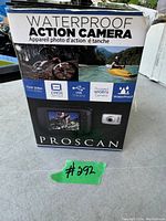 Box of a Proscan waterproof action camera showing front with usage images of biking and kayaking. Specs on front include 720p 30fps video, 1.3MP CMOS sensor, USB charging, rugged sports camera, waterproof label.
