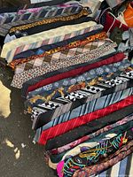 Wide view of assorted men's ties showcasing different patterns and colors including black, gold, striped, and ornate designs.
