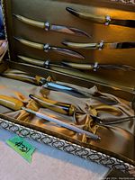 Photo of vintage carving set knives, fork and sharpening steel with yellow handles in original box with gold satin lining
