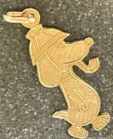 Front view of the yellow gold Snoopy pendant showing detailed engraving and bail attachment.