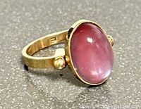 Front angle view of ring showing oval moonstone cabochon and band