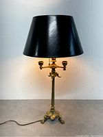 Full view of the antique French bronze electrified candle lamp with black lampshade.
