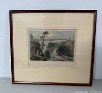 Overall view of framed lithograph showing the printed image with landscape and canal, mounted in a wooden frame with cream matting.