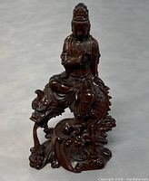 Frontal angle showing Guanyin seated on the dragon with detailed carving on robes, crown, and dragon features.