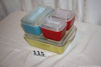Full set of four colorful vintage Pyrex refrigerator storage dishes stacked together showing colors and lids