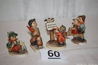 Front view of all four Hummel Goebel figurines showing detailed faces and colorful clothing.