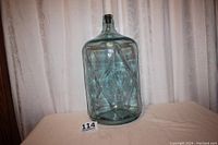 Full view of the large tinted blue glass spring water bottle showing the diamond pattern and overall shape.