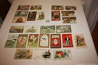 All three sets of postcards laid out on table showing Halloween, Thanksgiving, and Valentine Day cards