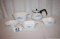 All five items included in the lot: one coffee server, one casserole dish, three petite pans, displayed on a white cloth background.