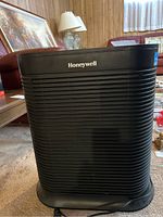Front view of black Honeywell air purifier with horizontal grille and brand name on front.