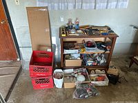 Wide view of cabinet and contents including milk crates, mirror, and assorted items placed on and around wooden shelving unit.