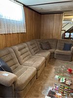 Five-piece beige sectional sofa arranged in wood-paneled room