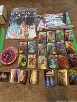 Marvel superhero magnets and trading cards arranged on floor with a round Chicago Bulls patch and baseball pennants in plastic wrapping visible