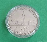 Obverse side of the 1939 Canadian silver dollar coin showing Parliament buildings and inscriptions.