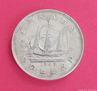 Photo of the Canadian silver dollar obverse side showing the ship and inscriptions.