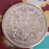 Reverse side of the 1960 Canadian 50 cent coin with the Canadian coat of arms and inscriptions.