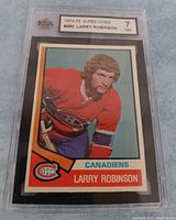 Front photo of the 1974-75 O-Pee-Chee #280 Larry Robinson hockey card, graded 7 by KSA, showing player image and team details.