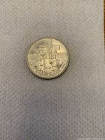 Obverse side of the 1984 Jacques Cartier commemorative silver dollar coin showing Jacques Cartier with cross and ship background.