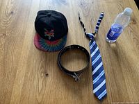 Overall view of the boys accessories lot showing tie, belt, ball cap.
