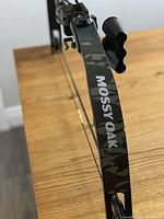 Close-up photo showing Mossy Oak branding and camo limb design of the compound bow.