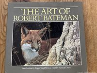 Front cover of The Art of Robert Bateman hardcover art book, shows gray cover with gold title, image of a fox, and introductory text credits.