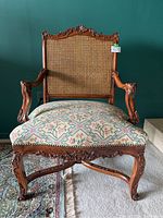 Front view of walnut frame armchair showing caned back and upholstered seat