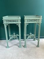 Front view showing pair of side tables with gallery-top surfaces, fretwork sides, and column legs