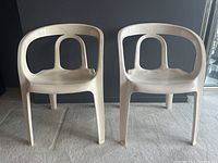 Front full shot of two chairs side by side on carpet against a dark wall