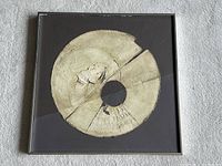 Frontal view of mixed media artwork in square metal frame