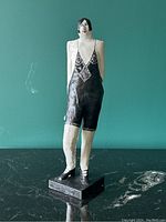Front view of hand painted vintage papier-mâché flapper woman sculpture in black bathing suit on black base.