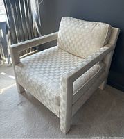 Three-quarter front view showing overall shape, woven fabric pattern, and right arm