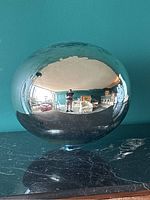 Full view of the glass gazing ball reflecting the room and photographer.