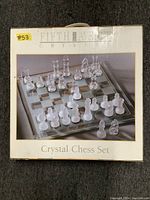 Box of the Fifth Avenue Crystal Chess Set with picture showing the glass board and the clear and frosted crystal chess pieces set up on it.