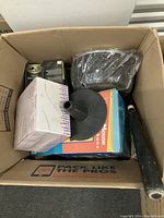 Box showing the microphone phone box and other boxed items along with a visible black baseball bat and coach light