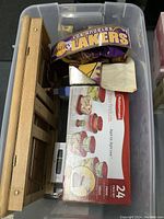 Photo showing Rubbermaid Tupperware set box, wooden whiteboard tray, and Nike+ FuelBand with Lakers branding