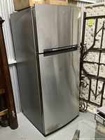 Front view of stainless steel Whirlpool top freezer refrigerator showing exterior