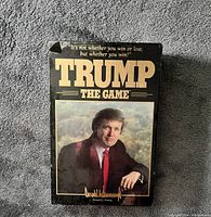 Front view of the TRUMP The Game board game box showing the title and Donald Trump's photo.