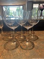 Eight large wine glasses grouped together on a countertop, showing their large bowl size and long stems.