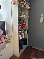Side view of shelving unit measuring approx. 32.5in L x 9.5in W x 72in H, showing stuffed animals on shelves for scale