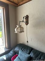 Wide view of the wall mounted crochet lamp over a couch near a window