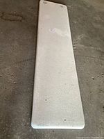 Top view of the white textured diving board showing minor dirt and surface wear.