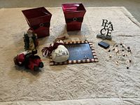 Photo of various Christmas decorative items including planters, Santa figurines, decorative signs and string lights